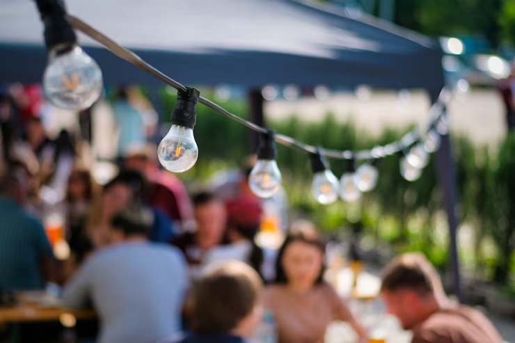 lampes-suspendues-au-restaurant-plein-air-plusieurs-visiteurs-arriere-plan-barbecue_1268-17681.png